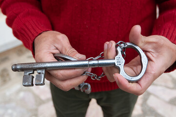 Un hombre sujeta la llave de una iglesia en la españa vaciada o despoblada.