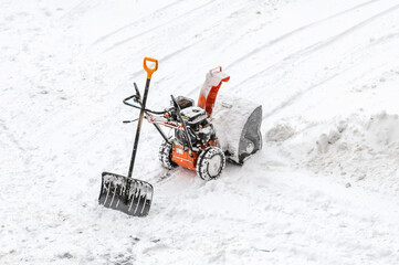 snow blower machine and shovel on snowy background, snowplower snow remover