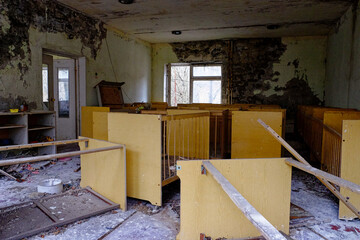 The image shows a dilapidated room with crumbling walls, debris on the floor, and disassembled...