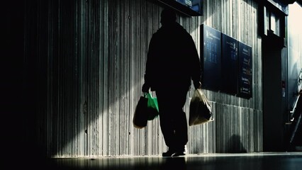 Silhouettes of people in daily commute in underground train platform station, moody atmosphere