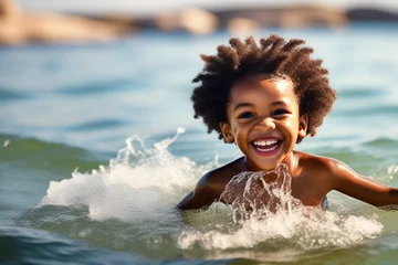 Foto op Canvas Close-up of a happy African American boy swimming and diving underwater, child having fun at sea in summer. Active healthy lifestyle, water sports and swimming lessons on summer holidays with a child. © Ekaterina