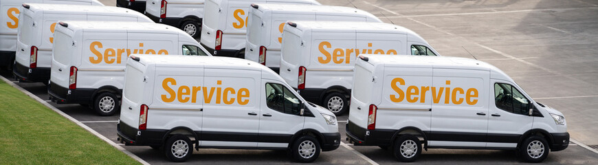 Service vans are parked in row. Commercial fleet