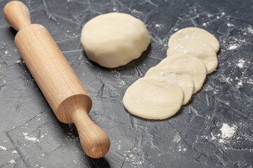 ball of fresh raw dough, flour and rolling pin top view