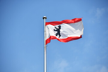 Berlin, Germany - June 9, 2023: State flag of Berlin waving against blue sky