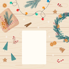 Christmas preparing flat lay square background. Christmas decorations, garland and white blank empty sheet for writing a list, wishes, card, letter on light wooden table. Template for holiday design