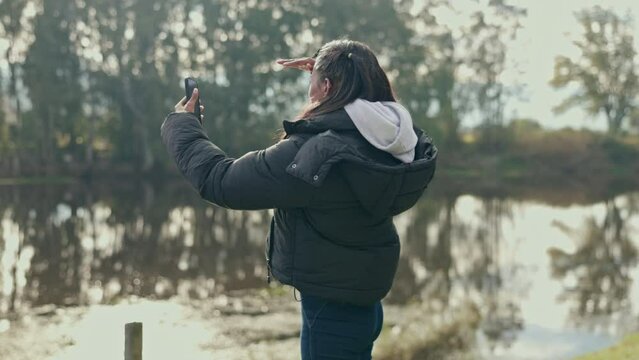 Hiking, phone and a woman lost in the forest, searching for signal, directions or a location in nature. Mobile app, map or navigation with a young female hiker looking for a network connection