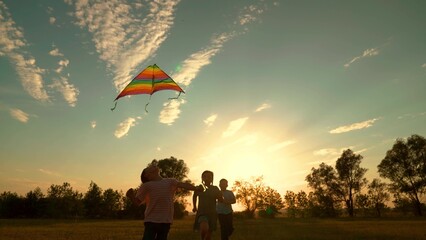 Happy kids run active lifestyle, Children play in park with kite. Boy girl, flying toy kite high in...