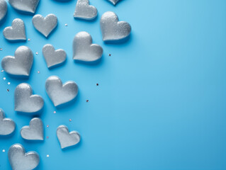 Cute sparkly silver glitter hearts on blue background