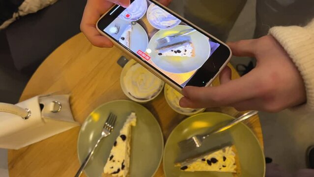 filming a cake in a restaurant with your phone, displaying your food in stories in Reelz, delicious, wonderful, interesting, adolescence, social networks, Internet, wi-fi, hands of a girl teenager