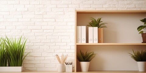 Office space with plants and folders against white brick wall, blurred background.