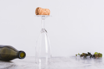 Sober January concept, cork on an inverted glass and bottle on the table - obrazy, fototapety, plakaty