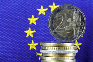 Euro coins and the blue flag of Europe