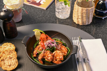 Photo spanish gambas tapa with crawfish on the top cooked with olive oil garlic and lemon