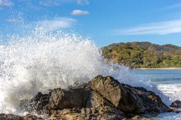 Powerful Wave Crashing into a Rock - 694537777