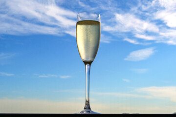 Flute glass of chilled champagne on the window sill of an airport lounge. No people.