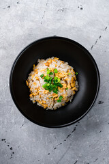 Rice scrambled eggs, green onions and parsley in a bowl.