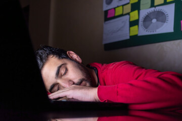 male sleeping on his desk during working