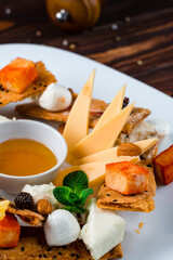 Fresh hard cheese, mozzarella, smoked cheese, blue cheese, oranges, strawberries, almonds, fir cone jam and dry bread.