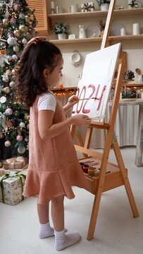 Little artist painting on drawing easel. Happy new year Eve 2024. Vertical video