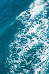 Dark stormy sea with foam, sea water surface, top view. Vertical background.