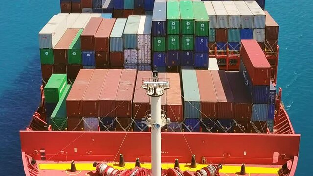 1 minute, full length footage of 300x48 meters long and width container ship. Close up, low level tracking over of a red cargo ship from nose side to center and stern