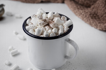 Hot cocoa with marshmallows in a white ceramic mug on a light background surrounded by winter things. The concept of a cozy holiday and New Year. Marshmallow with hot chocolate, Christmas drink