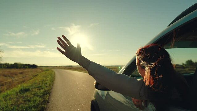 girl rides car with her hand out window, hand window smiling teenager sunny weather, adventure lifestyle, curly hair wind, waves his hand, girl waving her hand from car window, girl looking out car