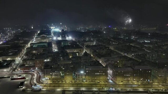 Helsinki.Finland-December 31.2021: High angle view showing the centre of Helsinki during new years eve. Wintertime. Fireworks. Beautiful cityscape. Nighttime. Drone slightly moving sideways.