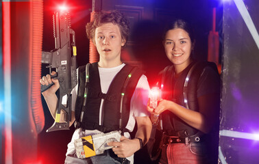 Guy and girl with lasertag guns standing in lasertag arena