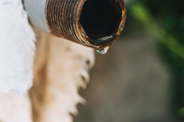 Broken crane. A drop of water falling from a rusty pipe hole. Higher tariffs, savings, poverty. Cutting off the water supply.