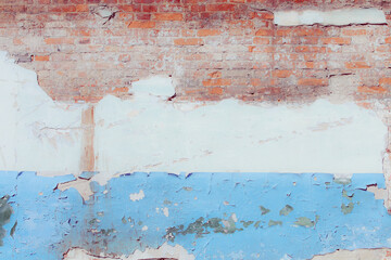 White and blue plaster on a dilapidated brick wall. Preparing the wall for repairs. Can be used as a background or poster. Fragment of a wall with bumps and peeling paint.