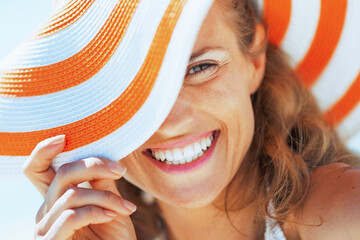 happy young woman in swimsuit and beach hat