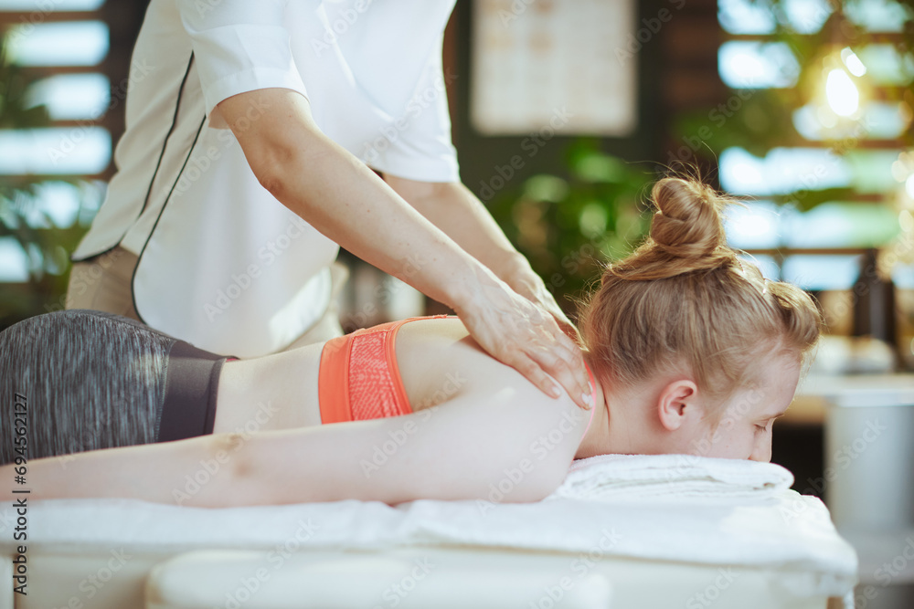 Wall mural female massage therapist in massage cabinet making massage