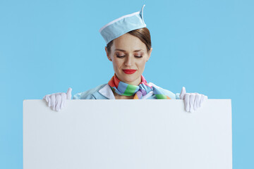 elegant flight attendant woman on blue showing blank board