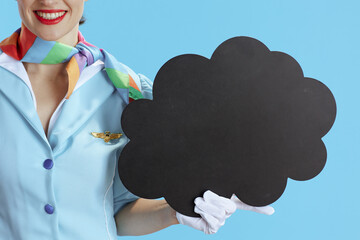 Female flight attendant on blue showing blank cloud shape board