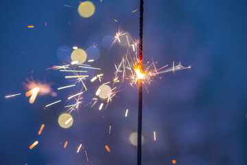 Beautiful sparklers made of sparklers on a New Year's bokeh background, on a blue background, Christmas mood, glitter, holiday background.

