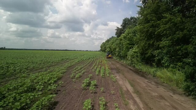 Grader works with tractor and levelling the field road