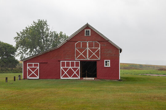 A Red Barn on a Green Meadow, Homestead in South Dakota on a Rainy, Stormy Autumn Day