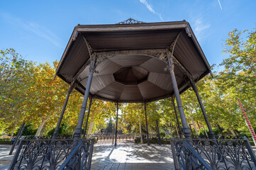 Wide angle view of a music kiosk with a wooden roof in a park in Granada (Spain)