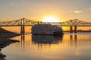 A Paddle Wheeler Cruise Ship at Sunset in Front of the John R Junkin Drive Bridge over the Mississippi River in Natchez, Mississippi 