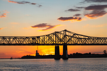 Silhouette of John R Junkin Drive Bridge Over the Mississippi River at Dusk, With Orange Sky, Sunset in Natchez, Mississippi