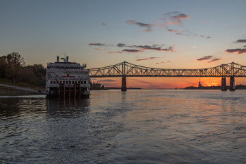 A Paddle Wheeler Cruise Ship at Sunset in Front of the John R Junkin Drive Bridge over the Mississippi River in Natchez, Mississippi 