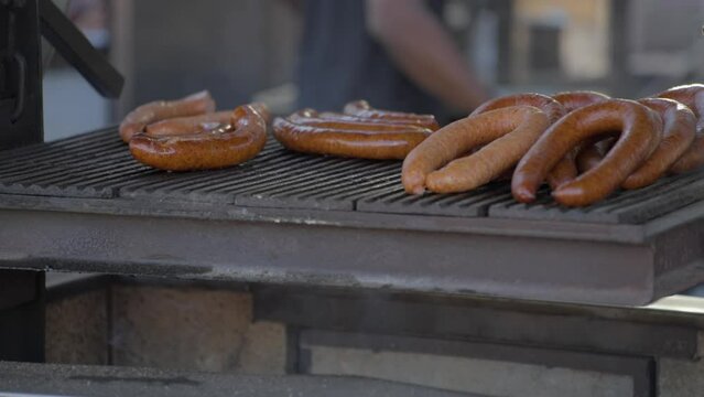 This video shows kielbasa sausages smoking on a fire grill. 