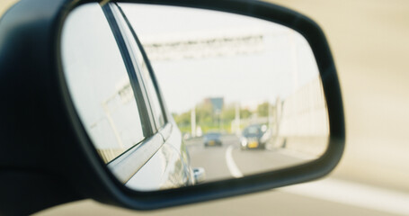 Side Rear View Mirror of a Driving Car