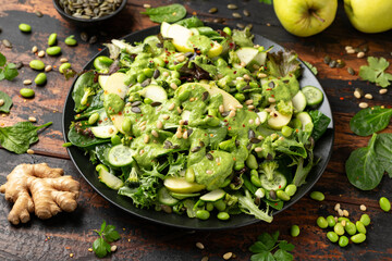 Super green salad with spinach, broccoli, apples, cucumber and edamame beans served with avocado,...