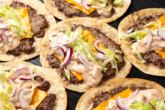 Homemade Taco smash burger with sauce, cheese, lettuce and red onion