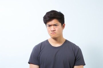 Fototapeta premium Confused Young Man with Frown on Plain Background. Generative AI.