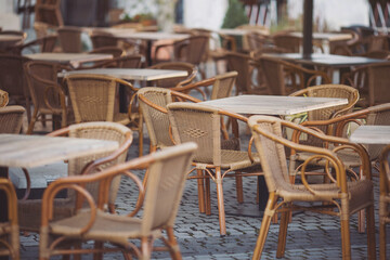 Coffeehouse cafe restaurant terrace. Wooden chairs and tables. Outdoor terrace concept. Shallow focus. Copy space. Old fashioned empty cafe terrace with vintage chairs and tables. Loft style cafe.