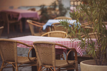 Coffeehouse cafe restaurant terrace. Wooden chairs and tables. Outdoor terrace concept. Shallow focus. Copy space. Old fashioned empty cafe terrace with vintage chairs and tables. Loft style cafe.
