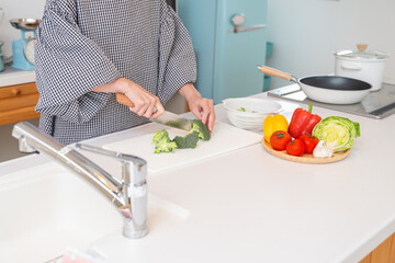 料理をする女性　手元　ブロッコリーを切る